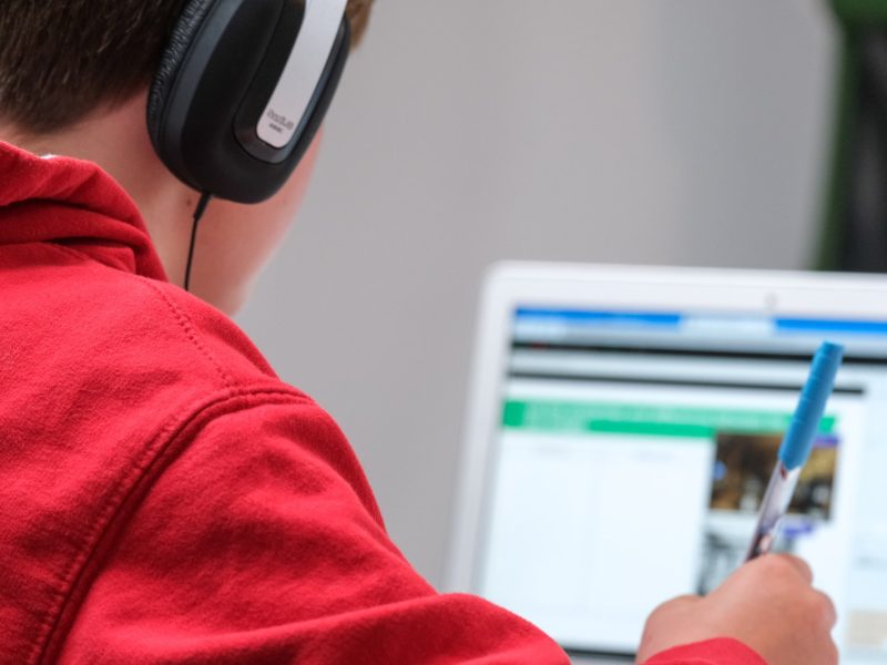 person in red shirt wearing black and gray headphones